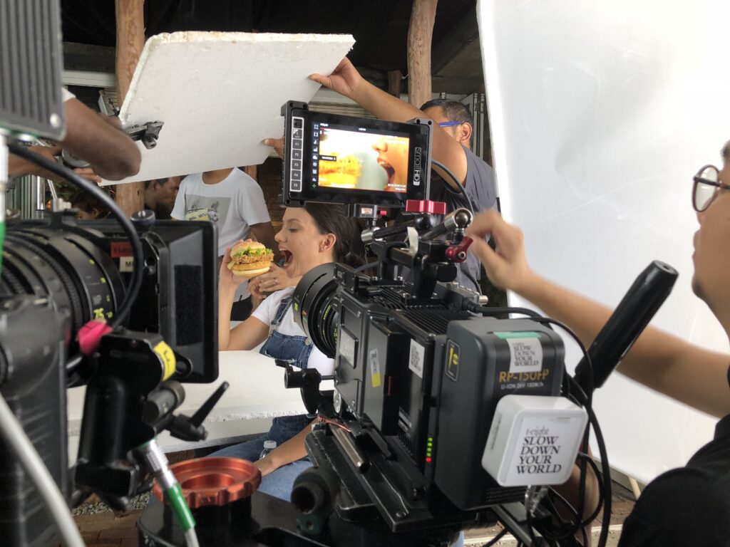 Behind the scenes of a T-Eight food video production shoot, with cameras, monitor and lighting crew filming a burger.