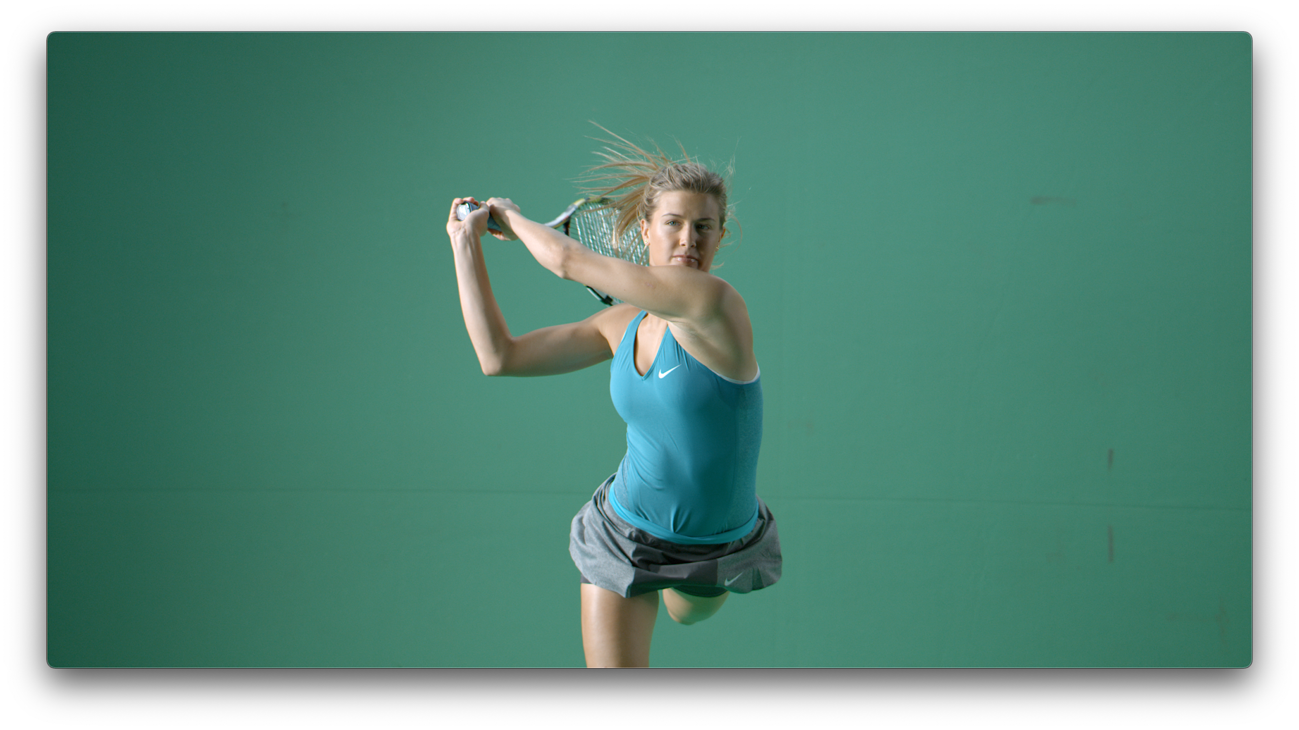 Tennis athlete in motion during a slow-motion sports shoot against green screen