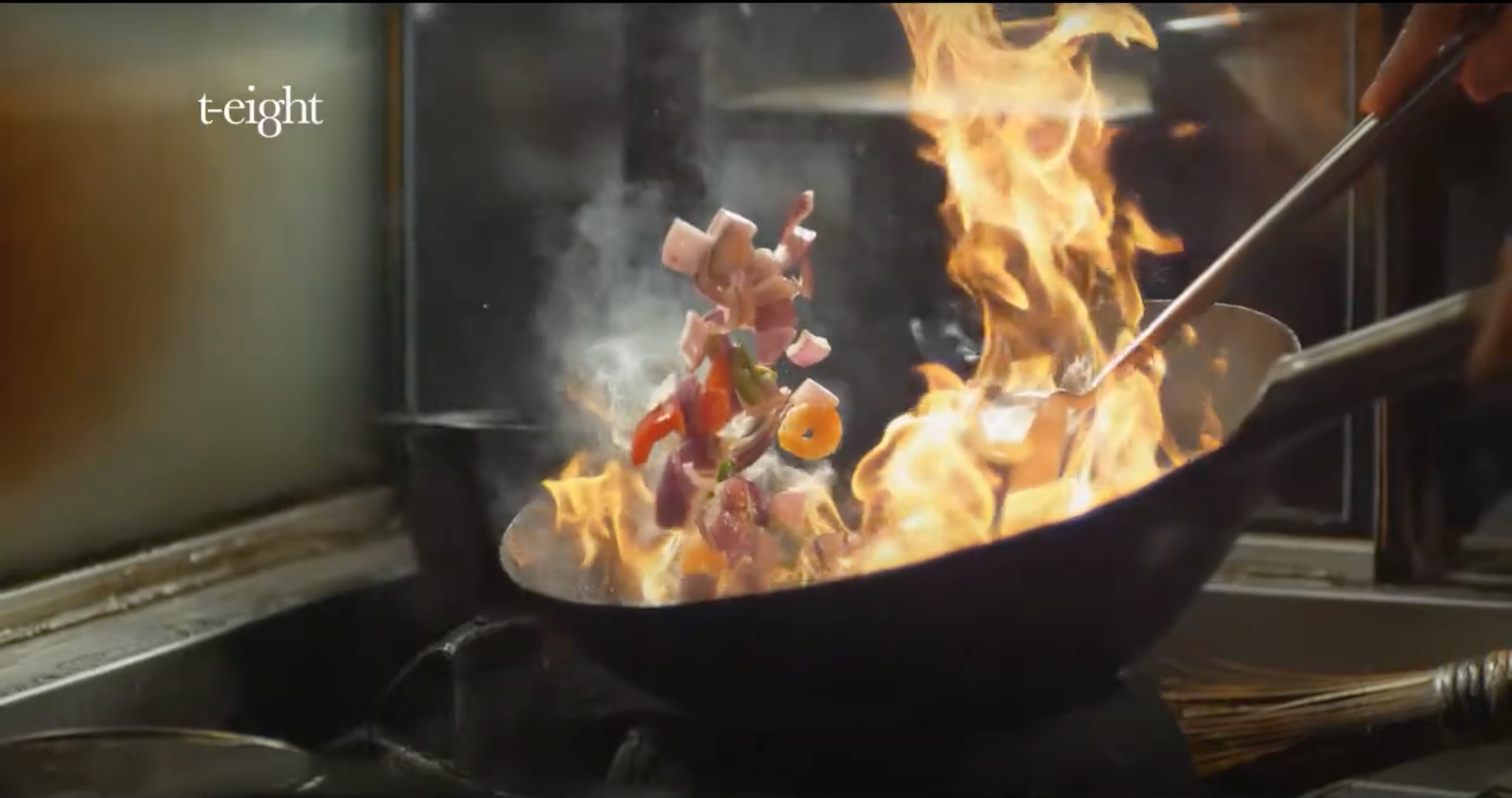 Ingredients tossed in a flaming wok during high-speed food filming