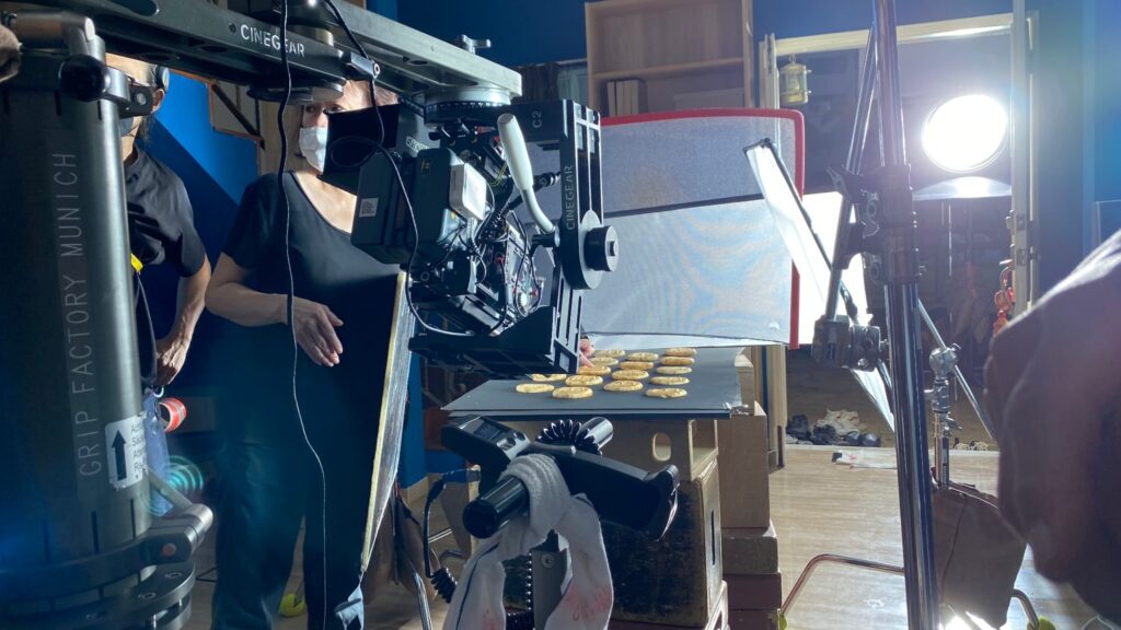Camera crew preparing a high-speed food shoot with camera, lighting and food props