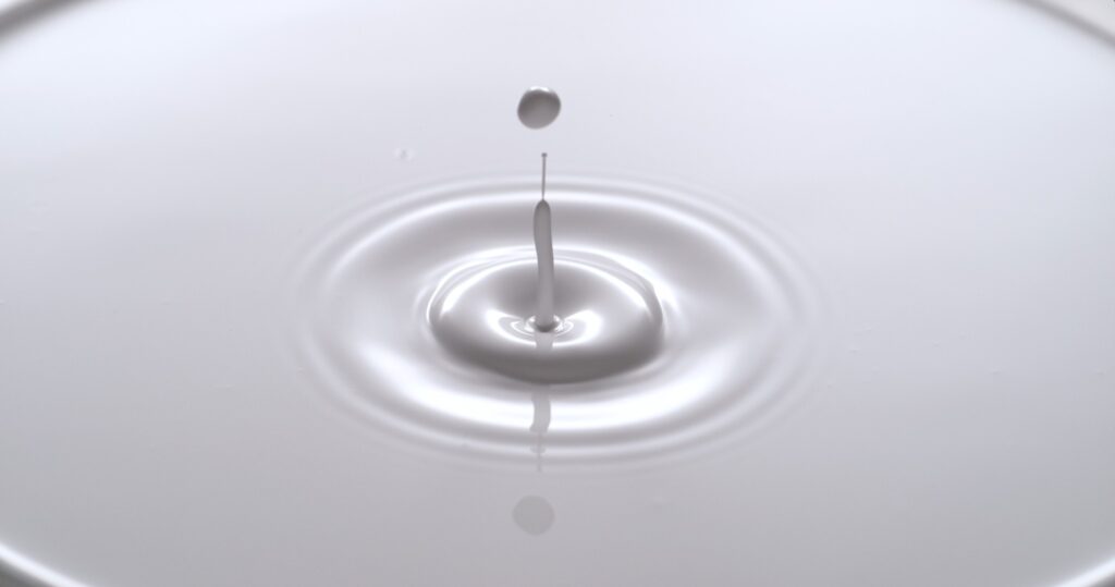 Milk droplet striking a liquid surface and creating concentric ripples